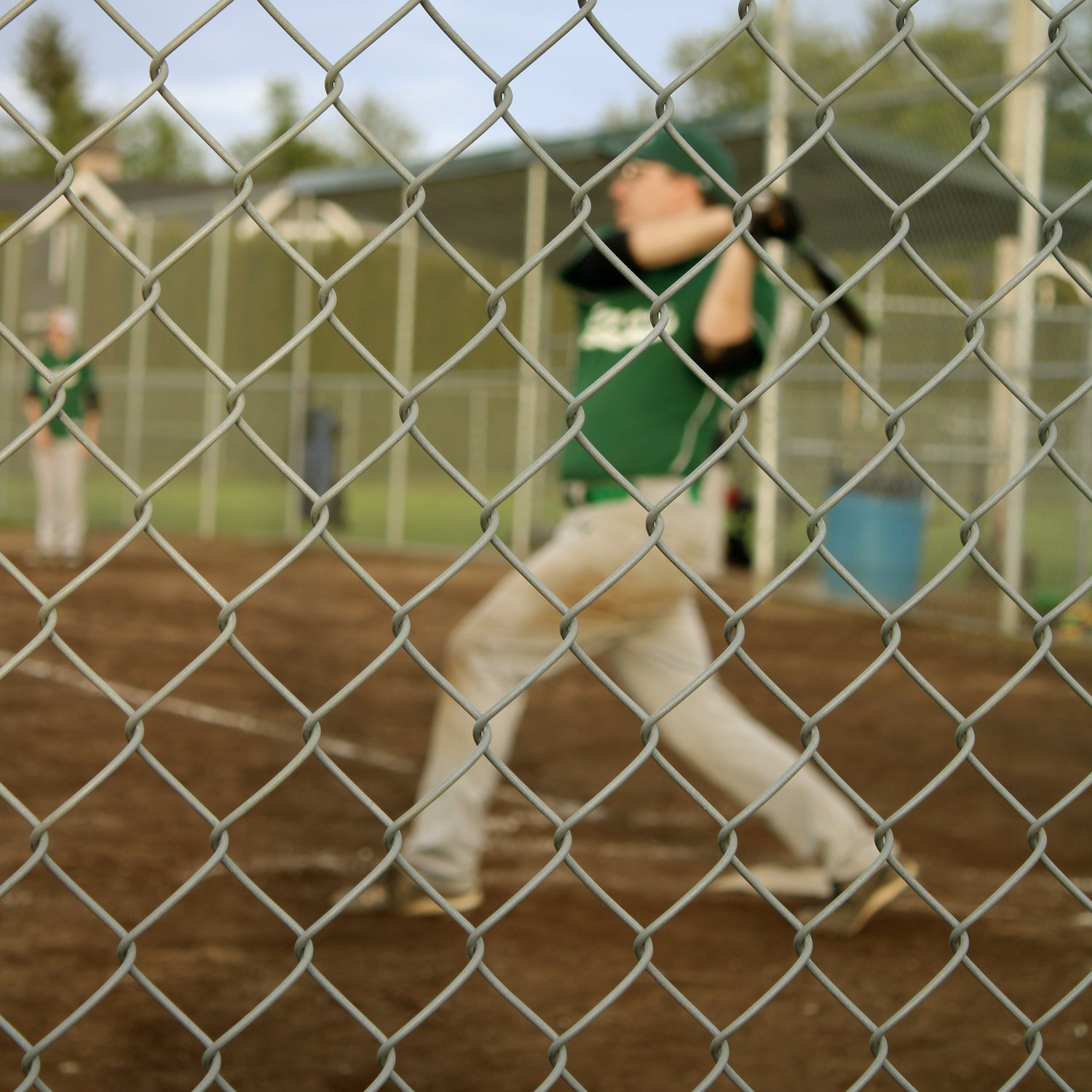 A baseball player hitting the ball over the fence